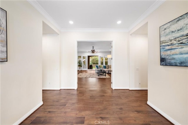 hallway with dark wood-style floors, ornamental molding, recessed lighting, and baseboards