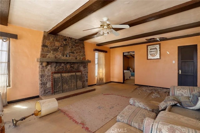 living room with a fireplace, beamed ceiling, and ceiling fan