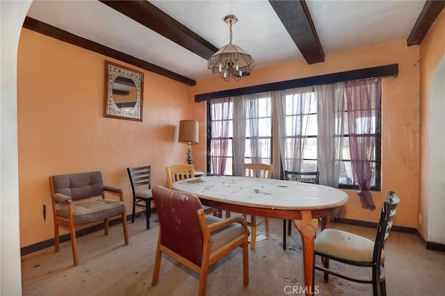 dining space featuring a notable chandelier and beam ceiling