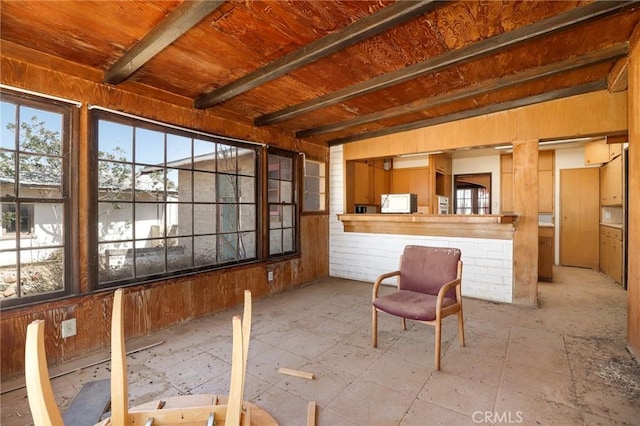 unfurnished sunroom featuring beam ceiling