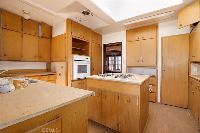 kitchen with sink, white appliances, and a center island