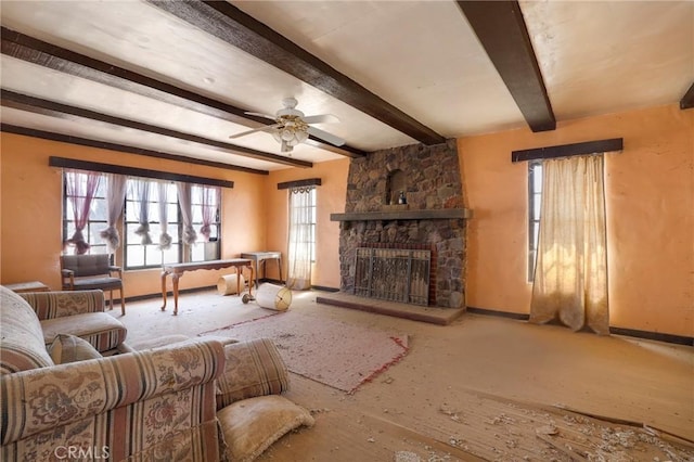 living room featuring a fireplace, beamed ceiling, and ceiling fan