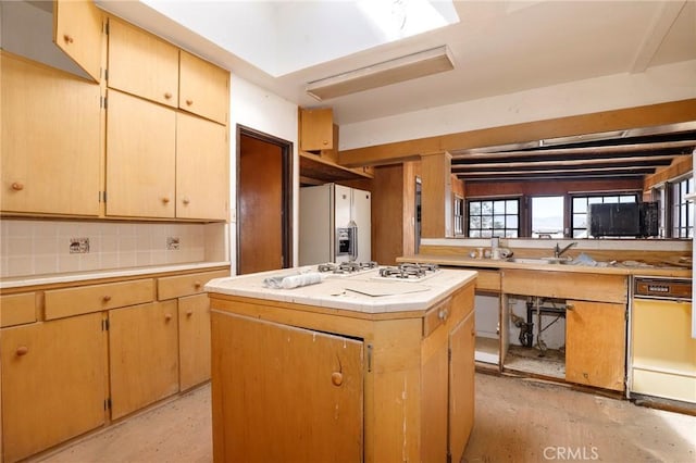 kitchen featuring white fridge with ice dispenser, backsplash, kitchen peninsula, and a center island