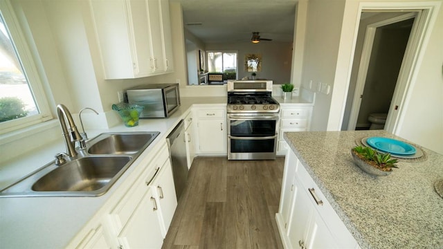 kitchen featuring plenty of natural light, sink, dark wood-type flooring, appliances with stainless steel finishes, and white cabinets