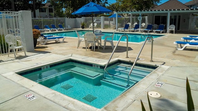 view of pool with a patio area and a hot tub