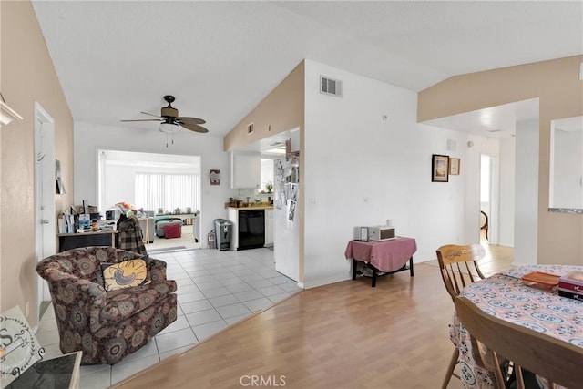 living room featuring light hardwood / wood-style floors, vaulted ceiling, and ceiling fan