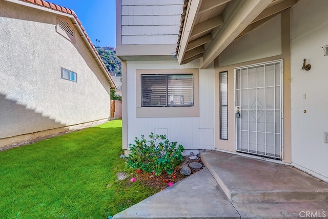 property entrance with a patio and a yard