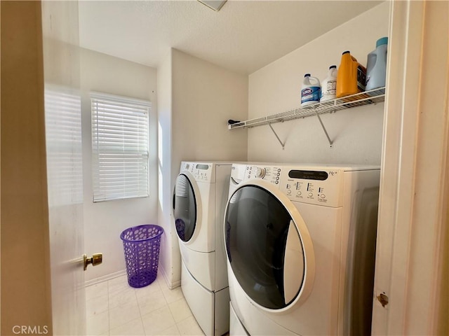 laundry area featuring laundry area, washer and clothes dryer, and light tile patterned floors