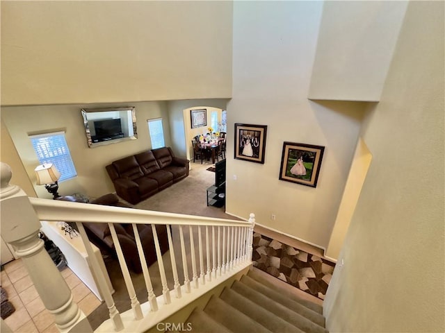 staircase featuring carpet floors, baseboards, and tile patterned floors