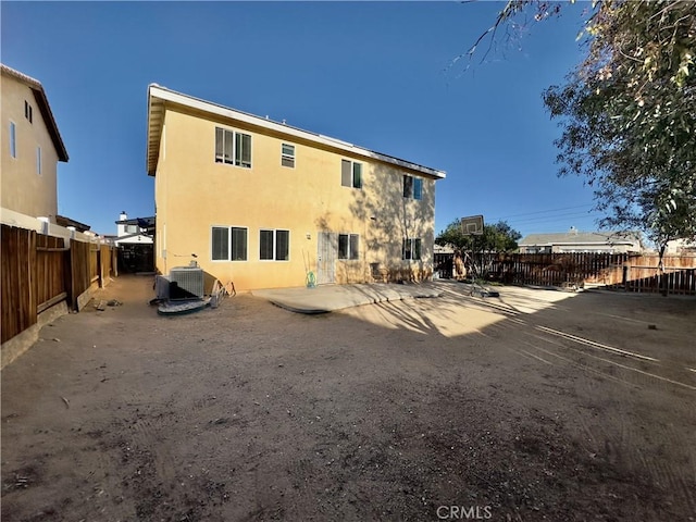 back of property featuring stucco siding, a fenced backyard, and central AC unit