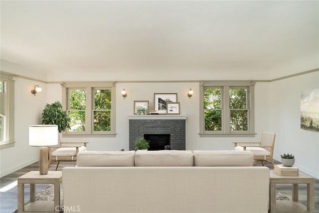 living area featuring a fireplace, wood finished floors, and baseboards