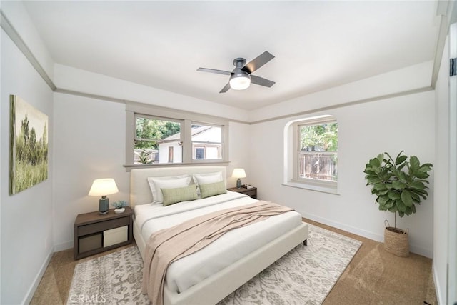 carpeted bedroom with baseboards and a ceiling fan