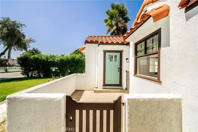 property entrance with a tiled roof and stucco siding