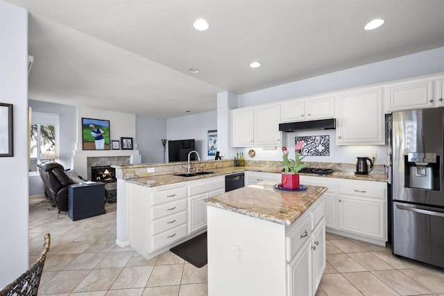 kitchen with a peninsula, a center island, stainless steel appliances, and open floor plan