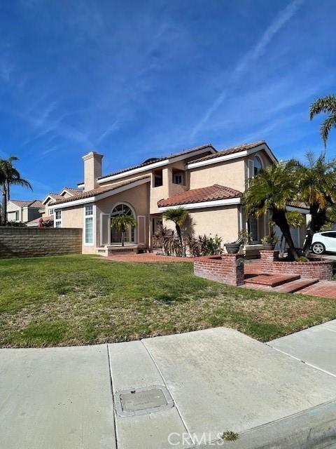 view of front of home featuring solar panels and a front yard