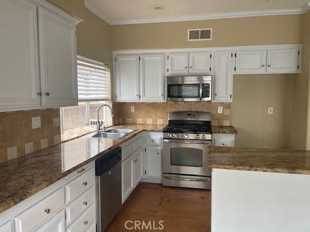 kitchen featuring light stone countertops, visible vents, a sink, white cabinets, and appliances with stainless steel finishes