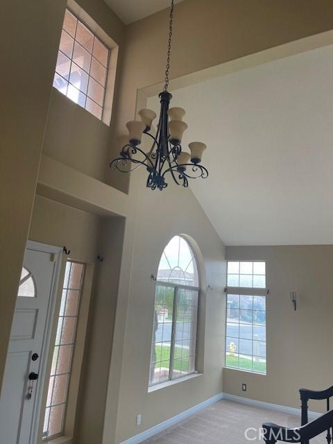 room details featuring carpet flooring, an inviting chandelier, and baseboards