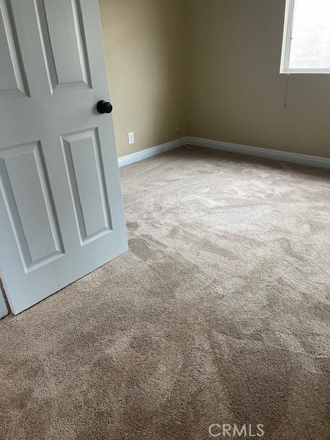 carpeted spare room with baseboards
