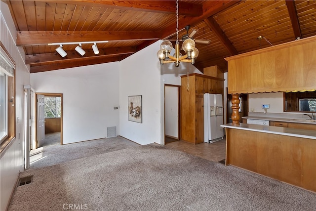 kitchen with sink, white fridge with ice dispenser, hanging light fixtures, wood ceiling, and light colored carpet