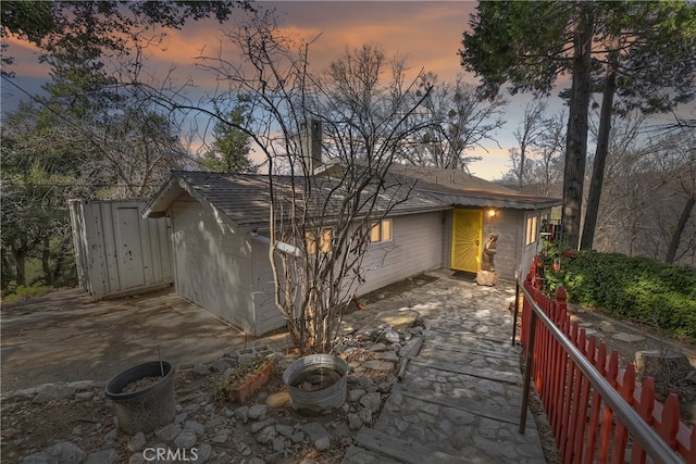 view of front of home featuring fence and roof with shingles