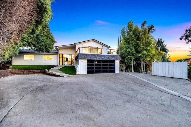 view of front of property with a garage, concrete driveway, and stucco siding