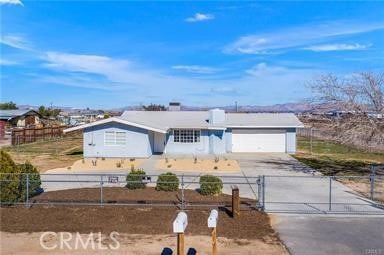 ranch-style house featuring a fenced front yard, concrete driveway, and an attached garage