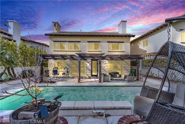 rear view of house featuring a chimney, fence, a patio area, a pergola, and stucco siding