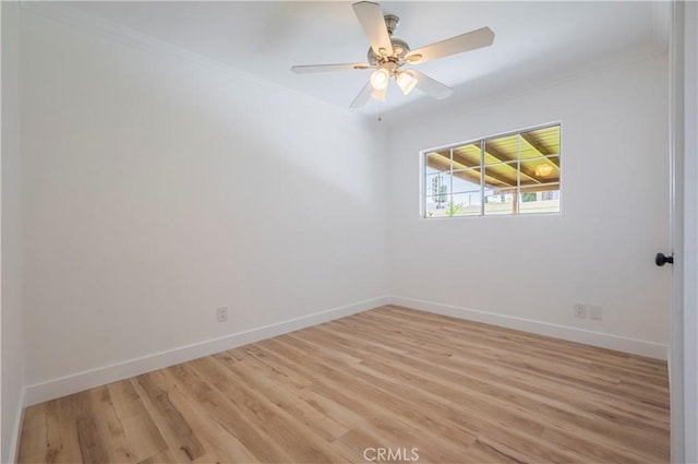 unfurnished room with ornamental molding, light wood-style flooring, and baseboards