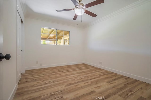 empty room with light wood finished floors, baseboards, ornamental molding, and a ceiling fan