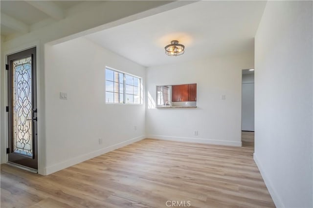 foyer entrance with light wood finished floors and baseboards