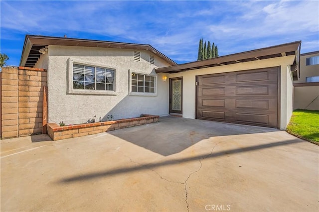 view of front facade featuring driveway, an attached garage, and stucco siding