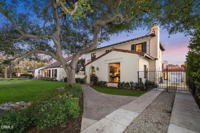 mediterranean / spanish house featuring a yard