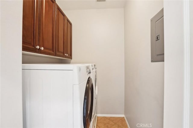 laundry area with washing machine and clothes dryer, light tile patterned floors, cabinet space, electric panel, and baseboards