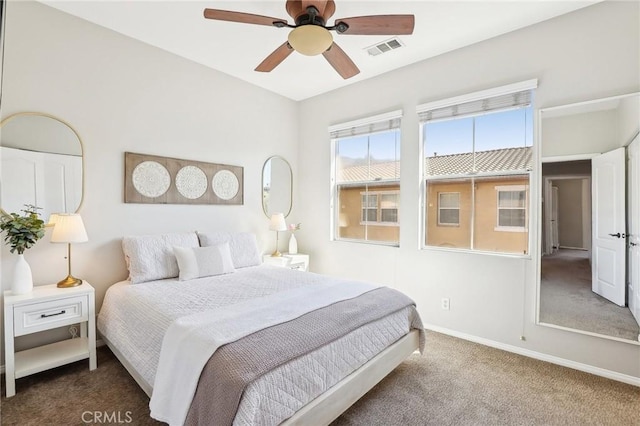 carpeted bedroom featuring a ceiling fan, visible vents, and baseboards