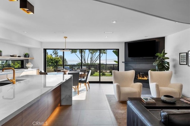 living area with light tile patterned flooring and a glass covered fireplace