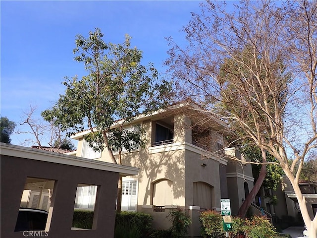 view of home's exterior featuring a balcony and stucco siding