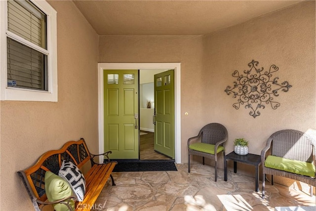 view of exterior entry featuring a patio area and stucco siding