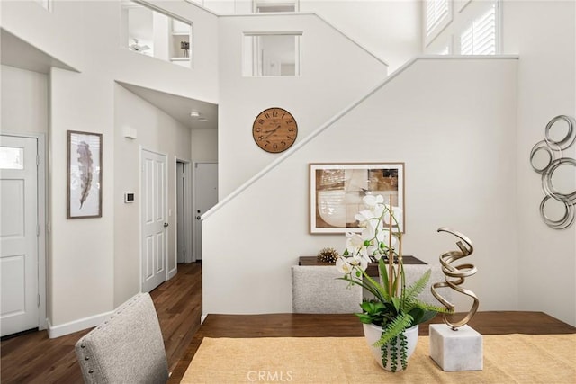 dining room featuring stairway, a towering ceiling, and wood finished floors