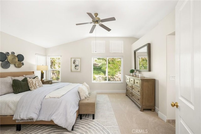 bedroom with multiple windows, vaulted ceiling, light carpet, and baseboards