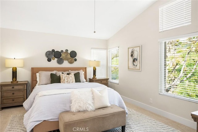 bedroom with high vaulted ceiling, light carpet, and baseboards