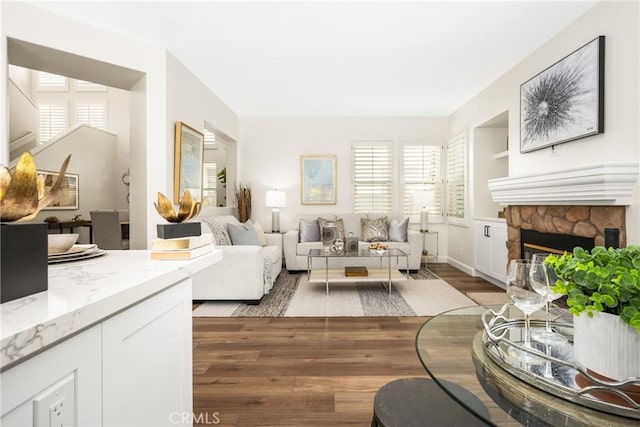 living room with a fireplace and wood finished floors