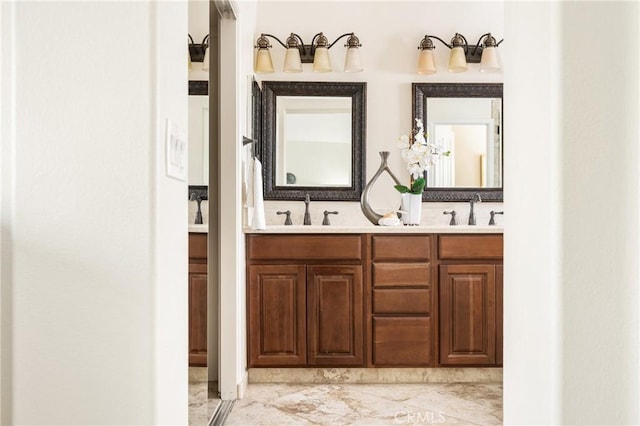 full bath featuring marble finish floor, a sink, and double vanity