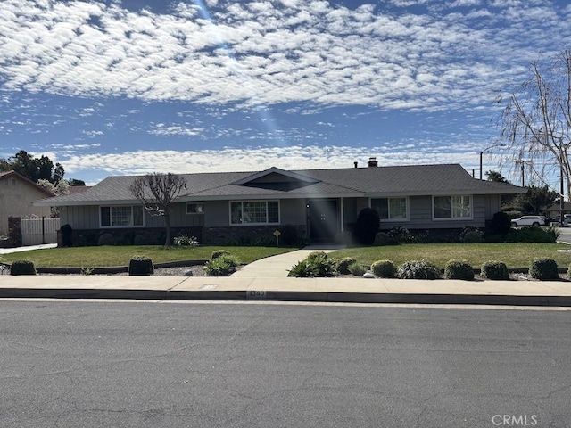 ranch-style house with driveway and a front lawn