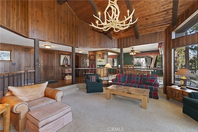 living area featuring wood ceiling, a notable chandelier, carpet, and wood walls