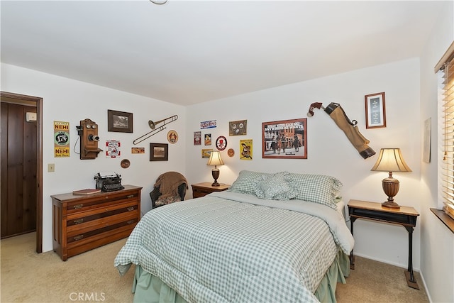 bedroom with light colored carpet and baseboards