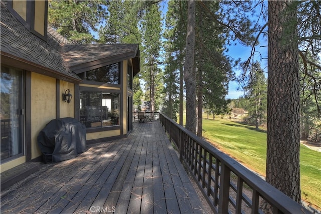 wooden terrace featuring a grill and a yard