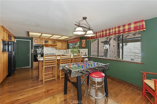 recreation room featuring baseboards and light wood-type flooring