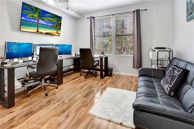 office space featuring baseboards, wood finished floors, and track lighting