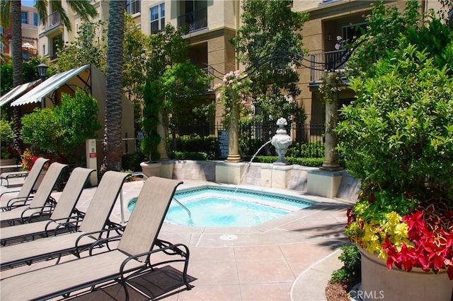 view of swimming pool featuring a hot tub and a patio