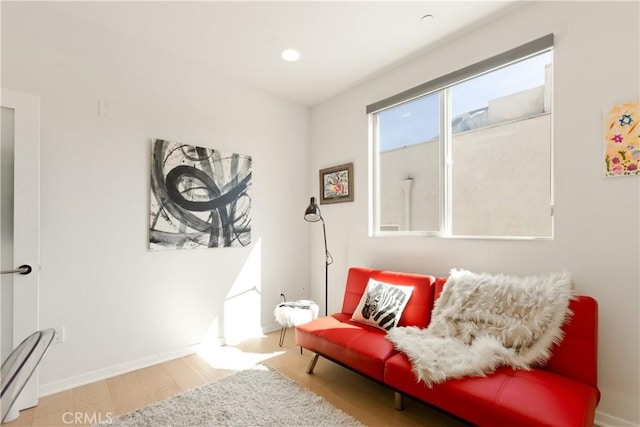 sitting room with baseboards and light wood finished floors